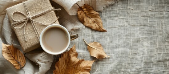 Poster - Autumn themed flat lay with coffee dry leaves a gift in craft paper on linen backdrop Emphasizes Autumn vibes with copy space image