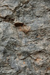 Aufkleber - Rock wall close-up view from below. Weathered gray granite with orange and brown patches. Light beige background provides contrast to dark rock face. Ideal for tech, eco, or adventure themes.