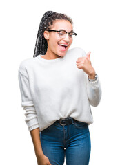 Wall Mural - Young braided hair african american girl wearing glasses and sweater over isolated background doing happy thumbs up gesture with hand. Approving expression looking at the camera with showing success.