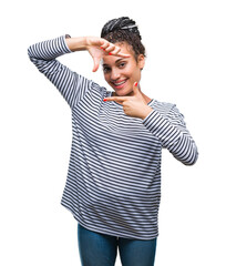 Canvas Print - Young braided hair african american girl wearing sweater over isolated background smiling making frame with hands and fingers with happy face. Creativity and photography concept.