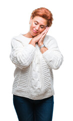 Canvas Print - Atrractive senior caucasian redhead woman wearing winter sweater over isolated background sleeping tired dreaming and posing with hands together while smiling with closed eyes.