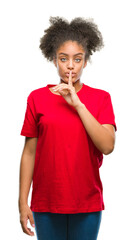 Poster - Young afro american woman over isolated background asking to be quiet with finger on lips. Silence and secret concept.