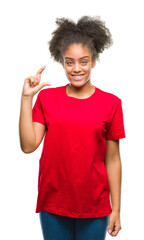 Poster - Young afro american woman over isolated background smiling and confident gesturing with hand doing size sign with fingers while looking and the camera. Measure concept.