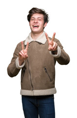 Poster - Young handsome man wearing winter coat over isolated background smiling looking to the camera showing fingers doing victory sign. Number two.