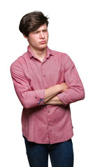 Wall Mural - Young handsome business man over isolated background skeptic and nervous, disapproving expression on face with crossed arms. Negative person.