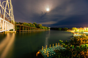 Wall Mural - Close-up view of the natural background of the wooden bridge, which is surrounded by mangrove forests, colorful leaves of the leaves, blown through the blurred coolness during ecological travel.