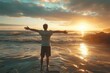 © isz - A man stands on the beach with arms outstretched, embracing the serene sunrise and reflecting on the beauty of nature