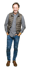 Canvas Print - Middle age handsome man wearing winter vest winking looking at the camera with sexy expression, cheerful and happy face.