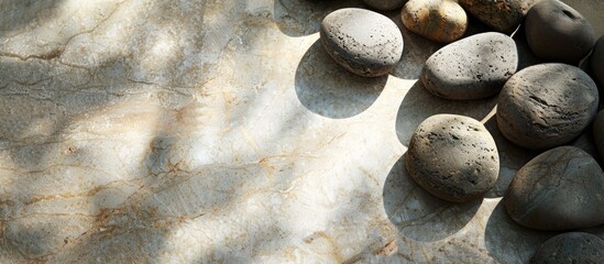 Wall Mural - Granite stones arranged on a beige surface with shadows, suitable for copy space image.