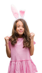 Sticker - Brunette hispanic girl wearing easter rabbit ears screaming proud and celebrating victory and success very excited, cheering emotion