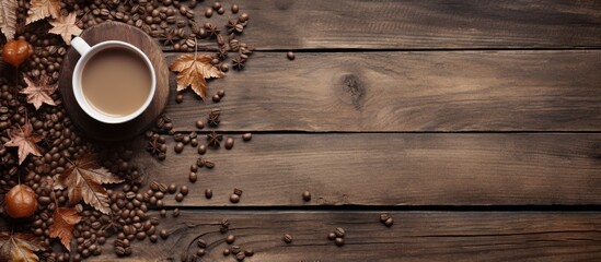 Poster - An old wooden background with scattered coffee beans, brown leaves, and a white coffee cup accompanied by a spoon set on maple leaves, offering a rustic ambiance for a copy space image.