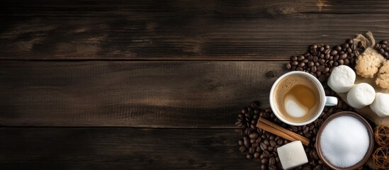 Sticker - Flat lay copy space image of coffee with milk, marshmallows, chocolate, and cane sugar on rustic burlap and dark wooden background.