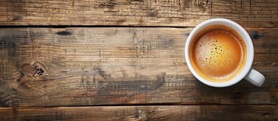 Poster - Top view of a coffee cup on a wooden table, with copy space image.