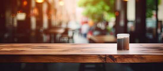 Poster - Wooden table with no items on it, featuring a blurred coffee shop in the background illuminated with bright clean light, perfect for product display with a copy space image.