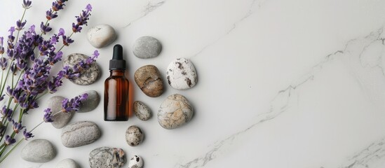 Poster - On a marble table, there are stones, a bottle of essential oil, lavender flowers, and a spacious area for text in the image.