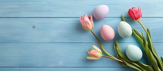 Aufkleber - Top view of colorful pastel Easter eggs with a tulip bouquet on a light blue wooden surface in a simple Easter greeting card background with available copy space image.