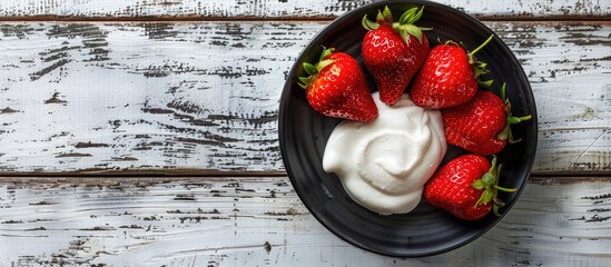 Poster - Healthy eating concept depicted by fresh ripe strawberries on a dark saucer, paired with natural yogurt, placed on a white wooden table with a copy space image.