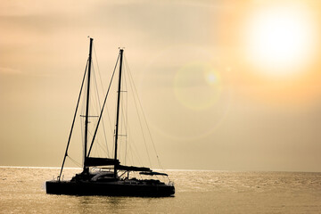 Wall Mural - A beautiful yacht sailing in the sea silhouette background