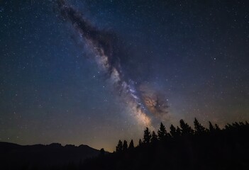 Wall Mural - A clear night sky filled with stars, with the Milky Way visible, above a silhouette of mountains or trees.