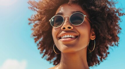 Wall Mural - Young female in bikini having fun outdoors on summer vacation. Close up of cheerful african woman in sunglasses looking away and smiling.