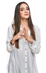 Wall Mural - Young beautiful woman wearing casual white shirt hands together and fingers crossed smiling relaxed and cheerful. success and optimistic