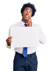 Poster - Handsome african american man with afro hair holding blank empty banner serious face thinking about question with hand on chin, thoughtful about confusing idea