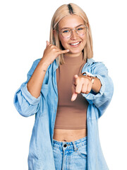 Sticker - Beautiful young blonde woman wearing glasses smiling doing talking on the telephone gesture and pointing to you. call me.