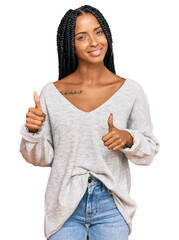 Beautiful hispanic woman wearing casual clothes success sign doing positive gesture with hand, thumbs up smiling and happy. cheerful expression and winner gesture.