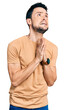 © Krakenimages.com - Hispanic man with beard wearing casual t shirt begging and praying with hands together with hope expression on face very emotional and worried. begging.
