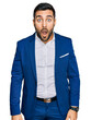 © Krakenimages.com - Young hispanic man wearing business jacket afraid and shocked with surprise and amazed expression, fear and excited face.
