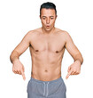 © Krakenimages.com - Handsome young man wearing swimwear shirtless pointing down with fingers showing advertisement, surprised face and open mouth