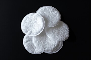 Poster - A collection of white cotton pads arranged neatly on a black background