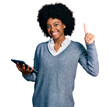 © Krakenimages.com - Young african american woman using touchpad device surprised with an idea or question pointing finger with happy face, number one