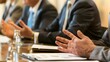 © Felippe Lopes - Close-up of business professionals in suits engaged in a serious discussion at a conference table.