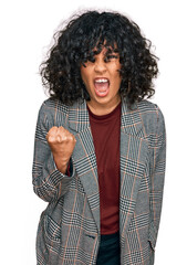 Poster - Young hispanic woman wearing business clothes angry and mad raising fist frustrated and furious while shouting with anger. rage and aggressive concept.