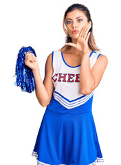 Poster - Young beautiful woman wearing cheerleader uniform hand on mouth telling secret rumor, whispering malicious talk conversation