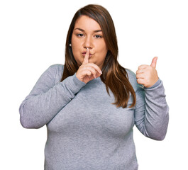 Wall Mural - Beautiful brunette plus size woman wearing casual clothes asking to be quiet with finger on lips pointing with hand to the side. silence and secret concept.