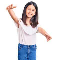 Sticker - Beautiful child girl wearing casual clothes looking at the camera smiling with open arms for hug. cheerful expression embracing happiness.