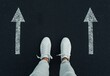 © Sparrowski - Choosing the Right Path - Decision Making Concept with Feet and Directional Arrows on Asphalt