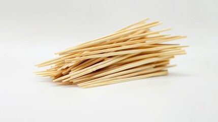 Poster - A pile of wooden toothpicks on a white surface, great for use in crafts or as a decorative element