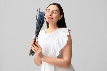 Sticker - Beautiful young woman with bouquet of lavender flowers on light background