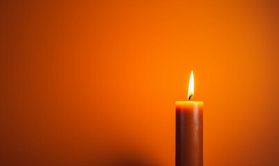 Single Lit Candle on Orange Background