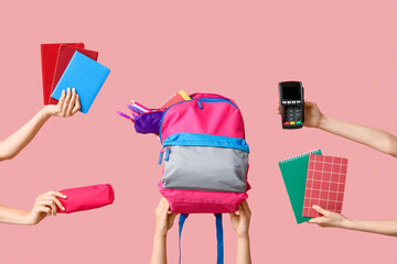 Wall Mural - Female hands with backpack, different school supplies and payment terminal on pink background, closeup