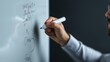 © porpia - Close-up of a man writing on a whiteboard with a marker, illustrating brainstorming, planning, and teaching activities.