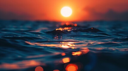 Poster - Waves lap gently at the surface of the ocean as the sun sets behind them, creating a blurred, golden glow