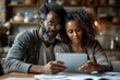 © Rayhanbp - A man and woman are looking at a tablet together