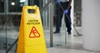 © CineLens2024/peopleimages.com - Caution, sign and cleaning for floor, janitor and hygiene service and dark at night in office. Mop, job and disinfection with equipment with warning and male person, disinfectant and wet ground