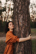 © Forewer - Happy adult lady hug tree trunk in outdoor leisure park activity. Concept of environment and ambient nature care. People love planet earth and stop deforestation lifestyle