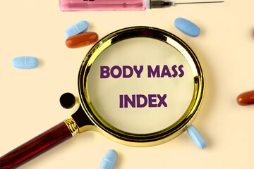 Wall Mural - Medicine and Body Mass Index concept. Copy space. Concept word Body Mass Index through a magnifying glass on a yellow background with scattered pills