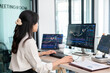 © MIND AND I - Young woman examines stock graphs at office desk